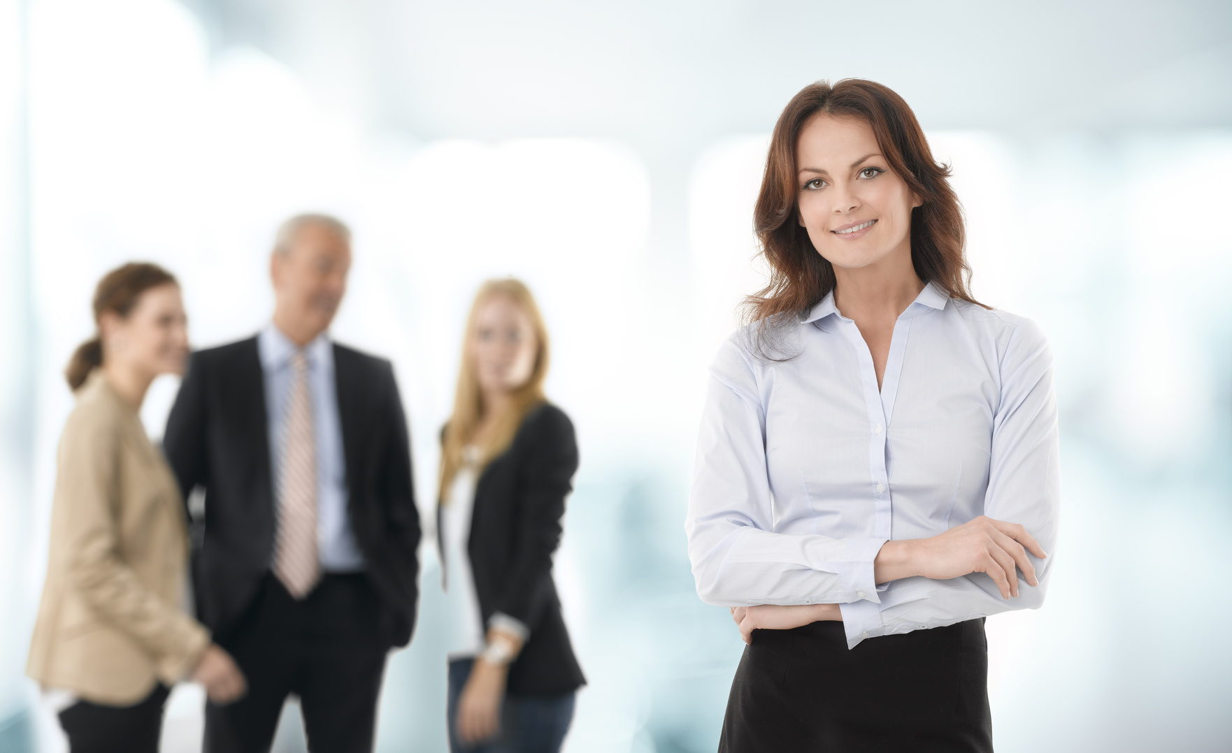 Beautiful businesswoman standing, people in the background.